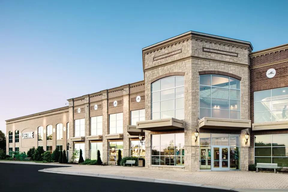 Stone and brick front of the Life Time Ashburn-Sterling club with its tall glass entrance