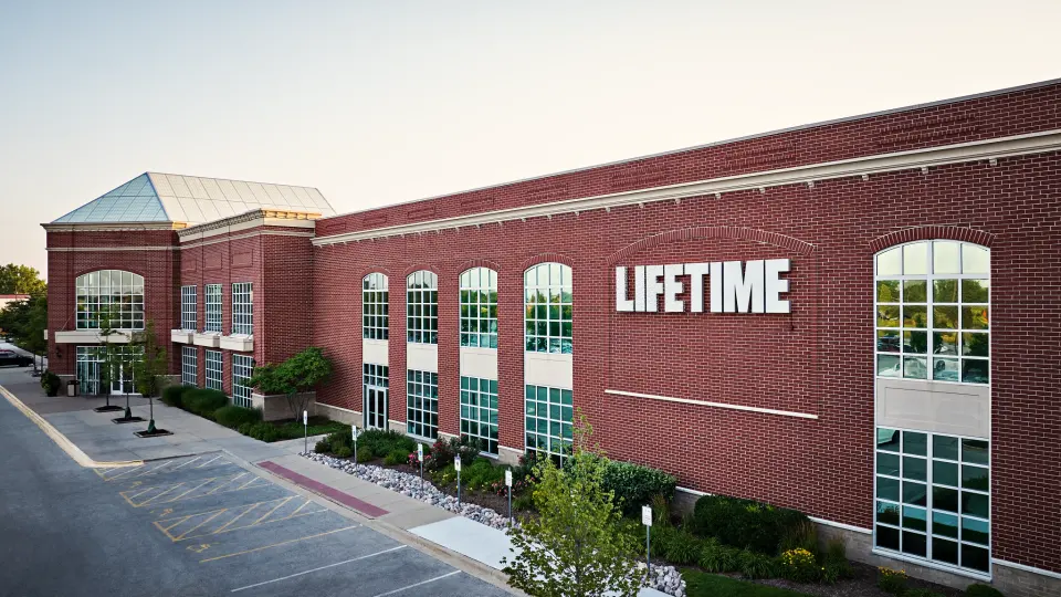 Red-brick Life Time club building with its glass-roofed corner and LIFETIME sign