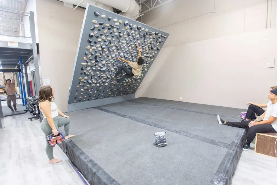 Climber on the Tension Board above the matting