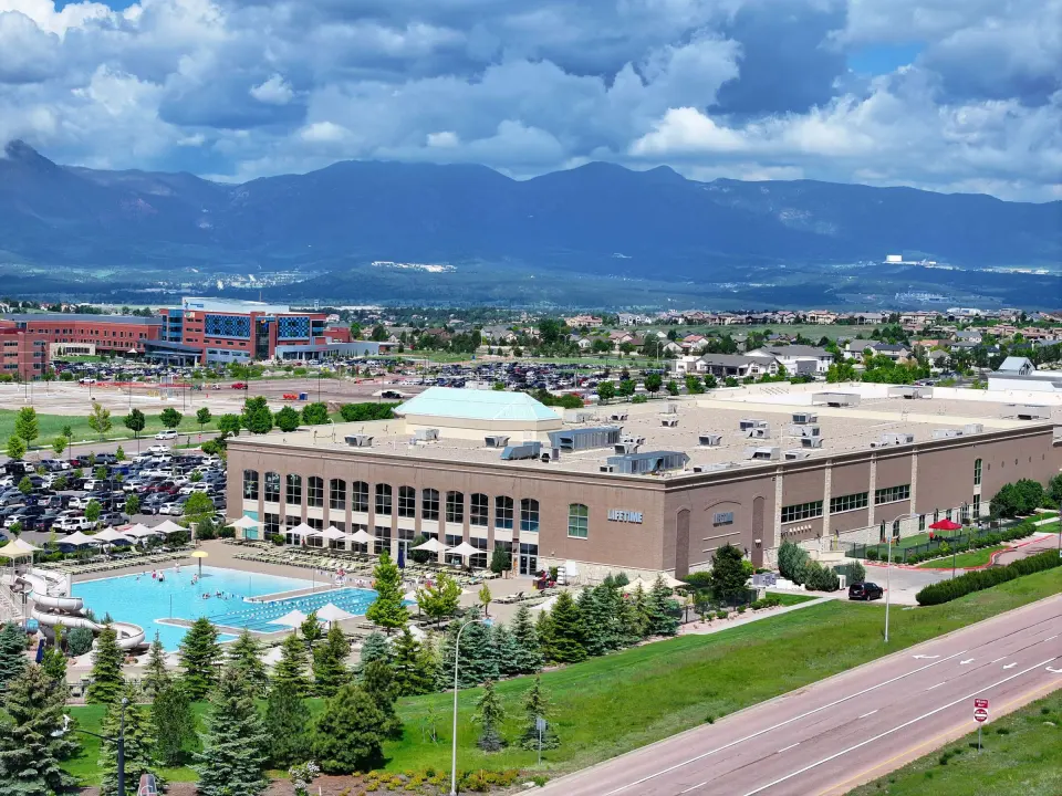 Aerial view of the club building and its outdoor pool, with mountains behind