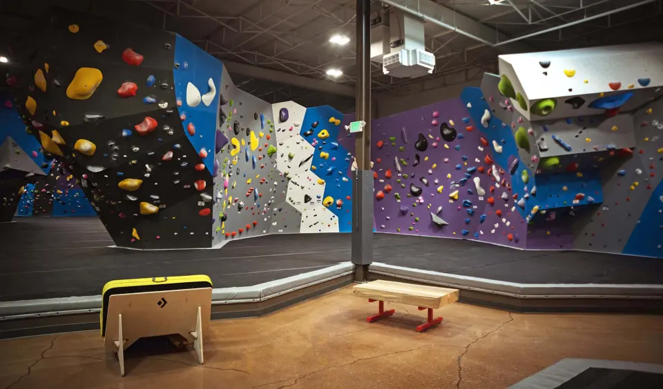 Purple, blue and grey bouldering walls above thick padded flooring