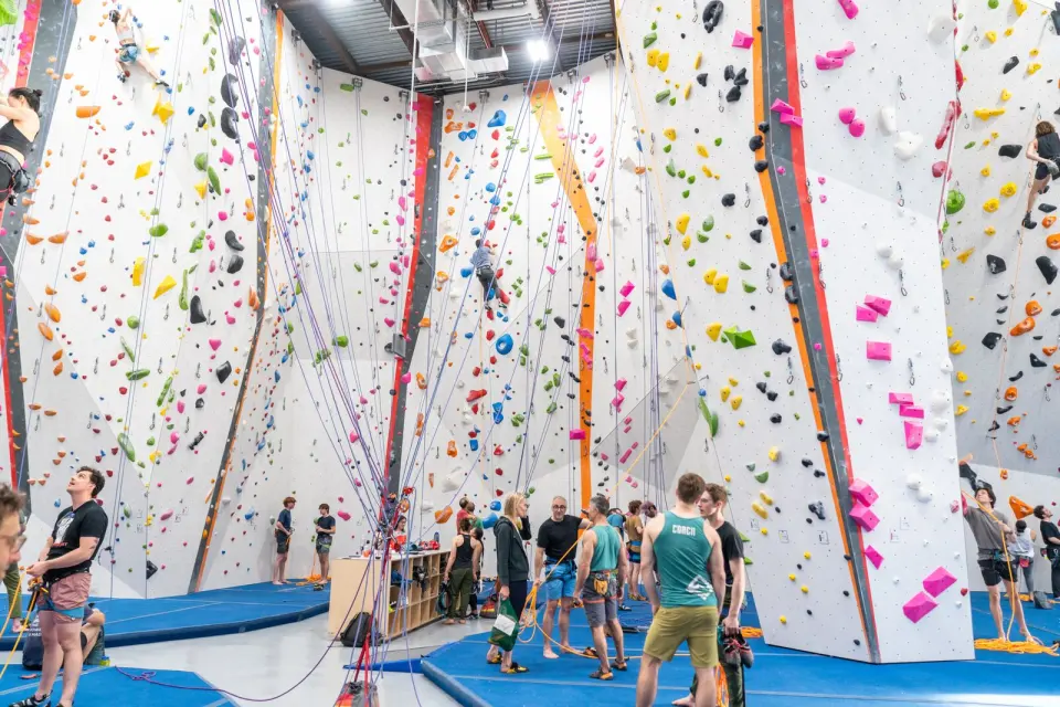 Climbers and belayers below the tall roped walls of the main hall
