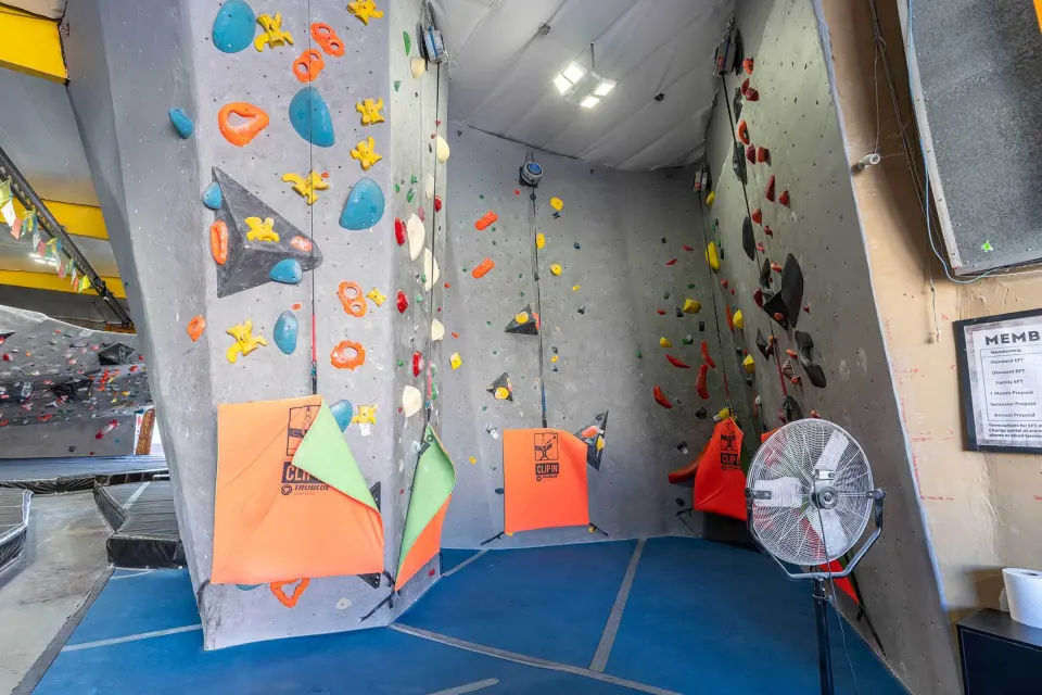 Auto-belay lines on a tall pillar beside the bouldering area