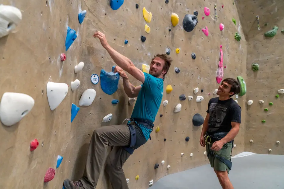 Climber pulling onto a sand-coloured wall
