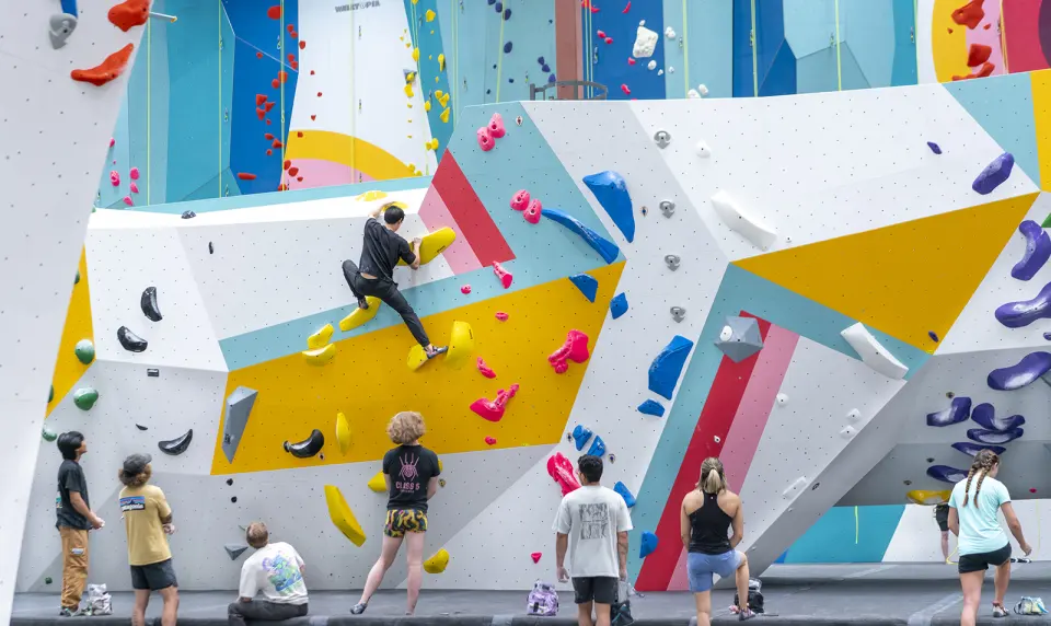 Climbers on the colourful bouldering walls