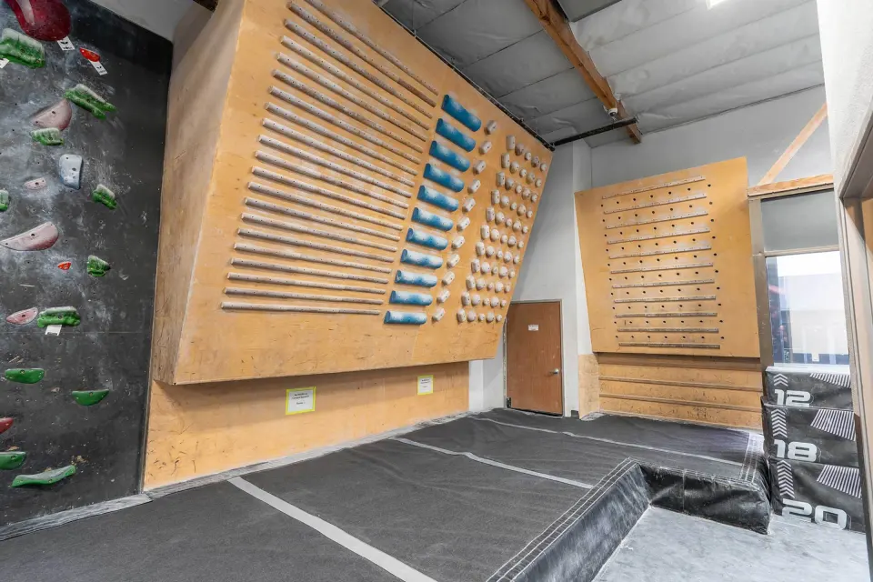 Campus board and wooden training boards beside the bouldering walls