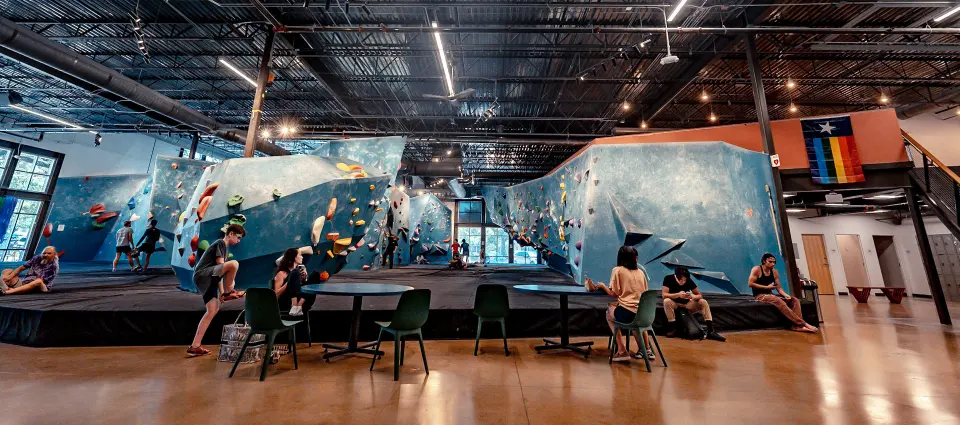 Blue bouldering walls behind the seating area on the main floor