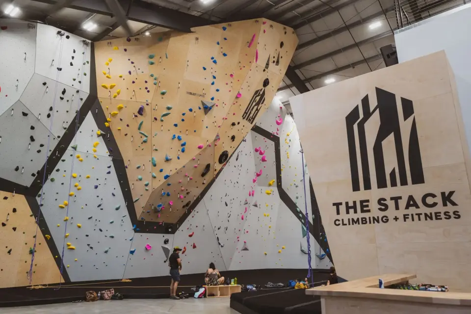 Tall roped walls and a large overhanging feature behind the front desk and The Stack logo