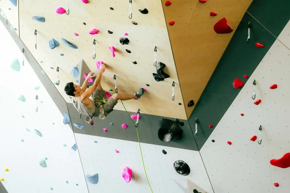Climber on a rope under a steep plywood panel