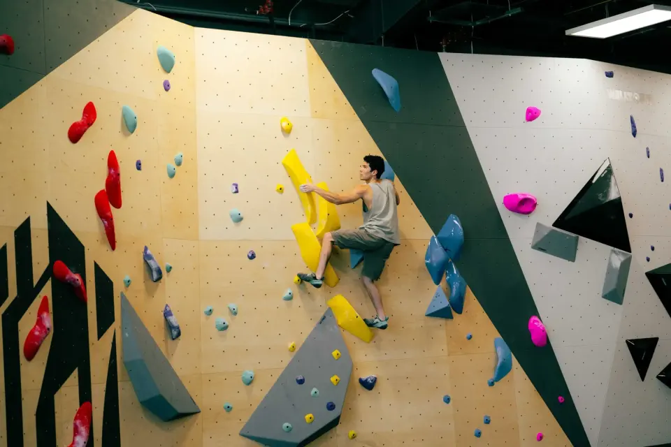 Climber on yellow holds on the bouldering wall