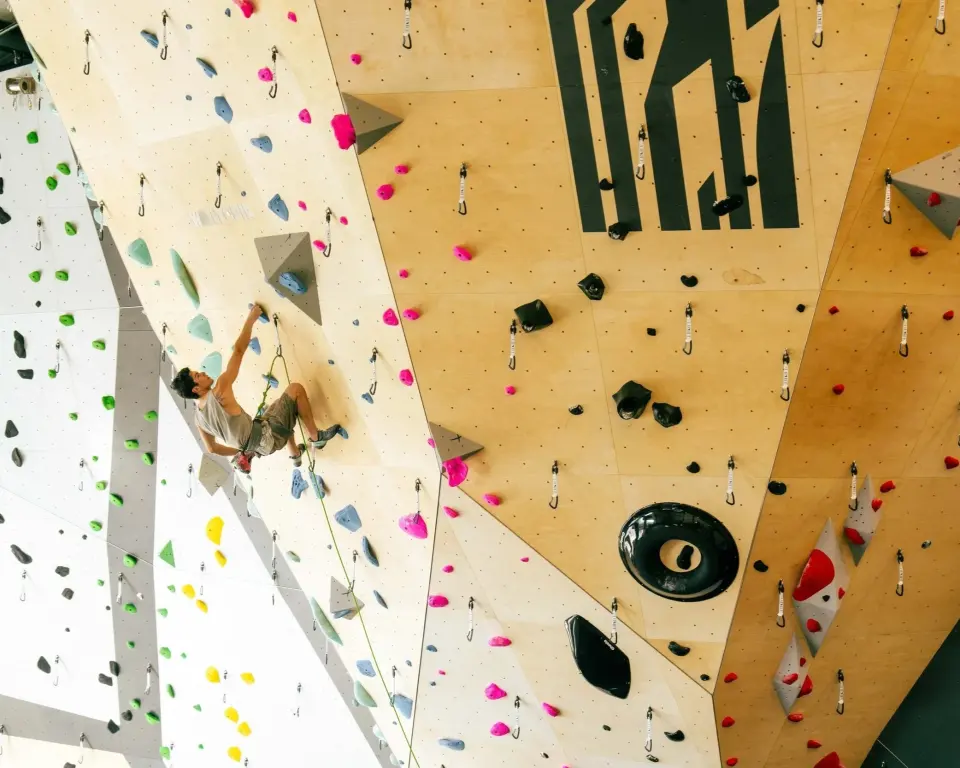 Rope climber below the Stack logo on a plywood wall
