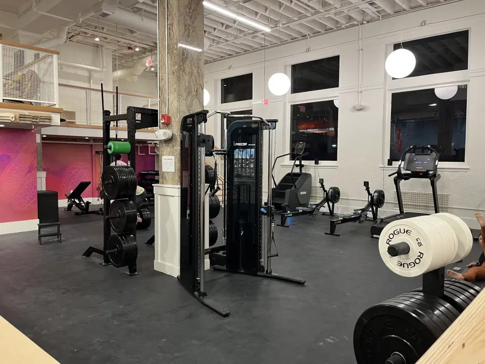 Fitness area with racks, a cable machine, rowers and treadmills
