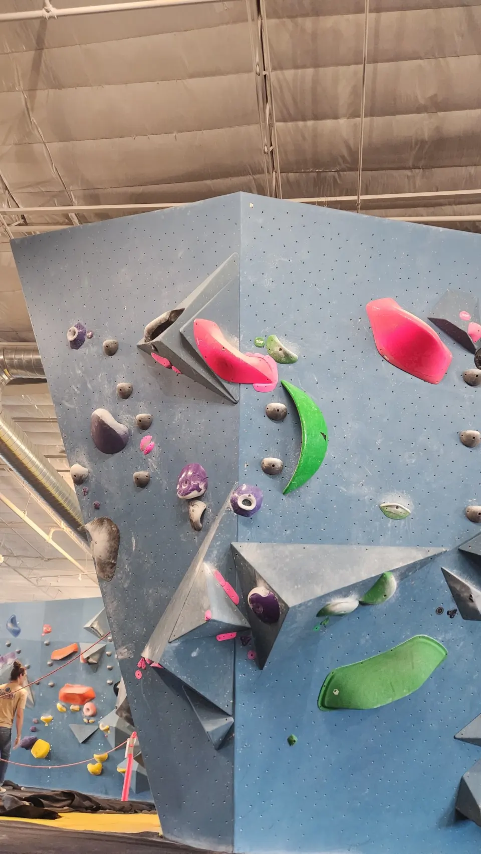 Tall boulder with volumes and coloured holds