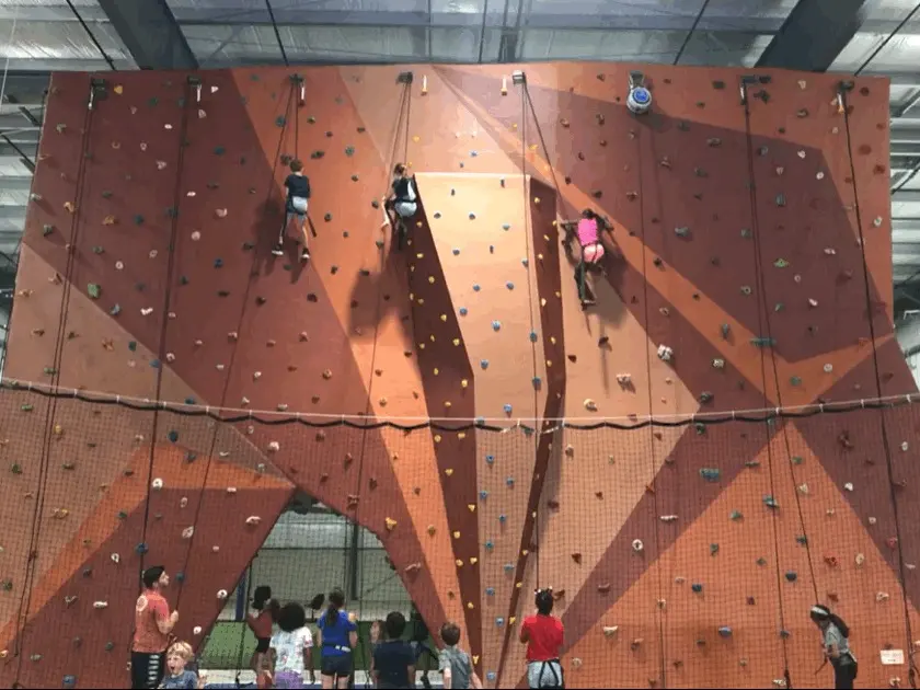 Climbers on the main top-rope wall, with its arch and angled panels