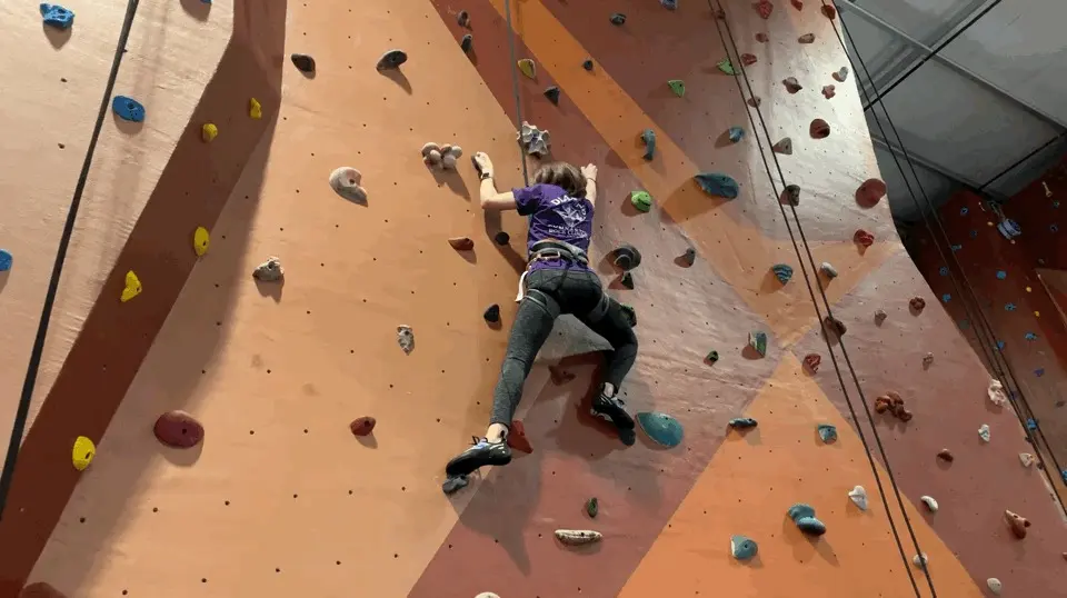 Climber on a top rope partway up the wall