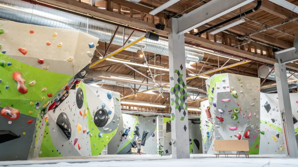 Overhanging green and grey boulders under the factory roof