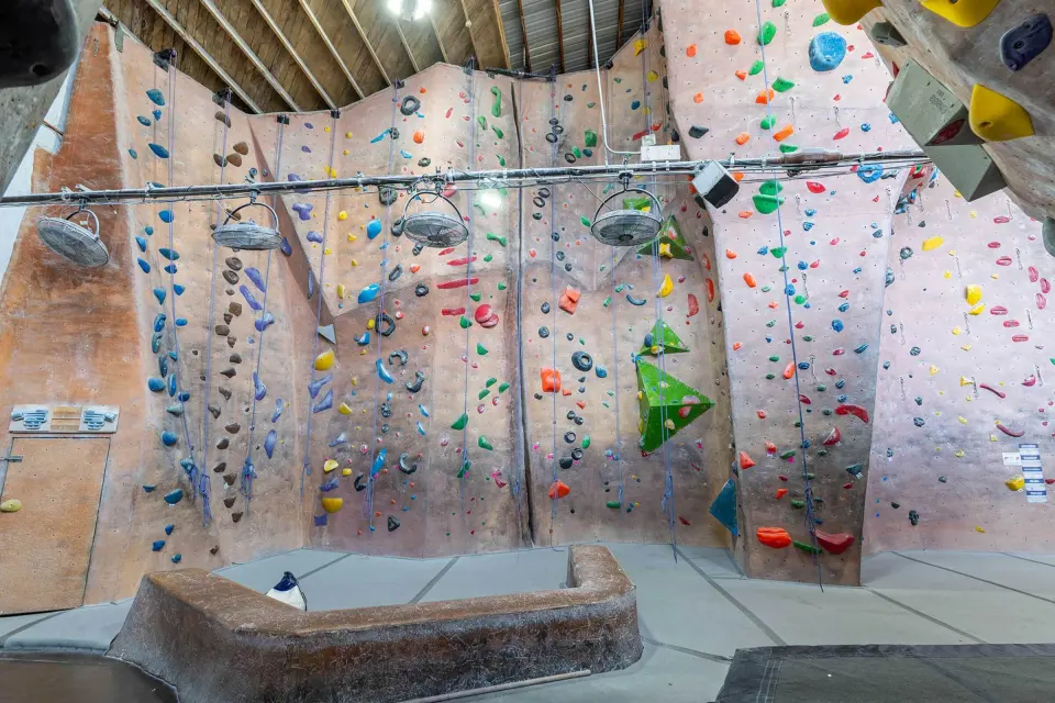 Top-rope and auto-belay wall with fans overhead