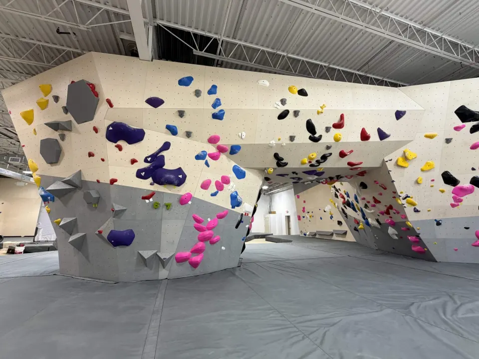 Bouldering walls with a long overhanging prow above grey matting