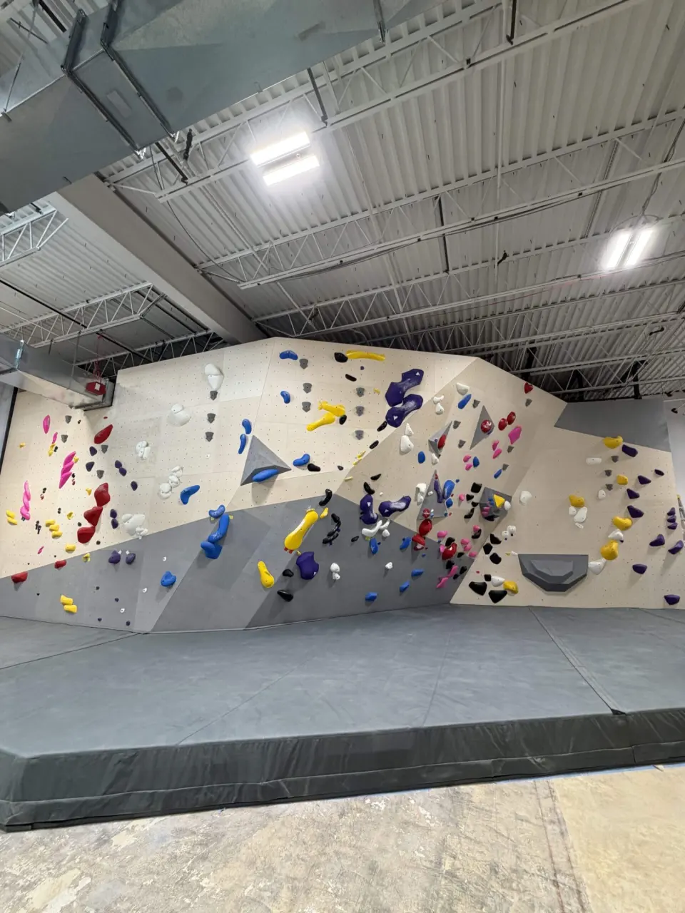 Angled bouldering wall in a corner of the gym