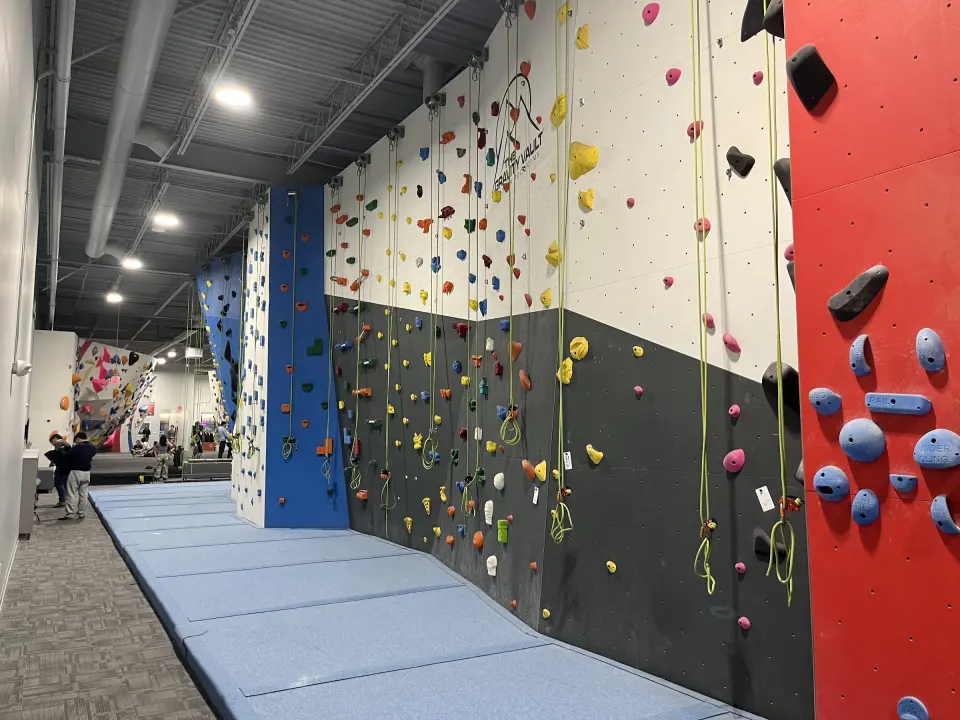 Top-rope walls with grey and red panels above blue matting
