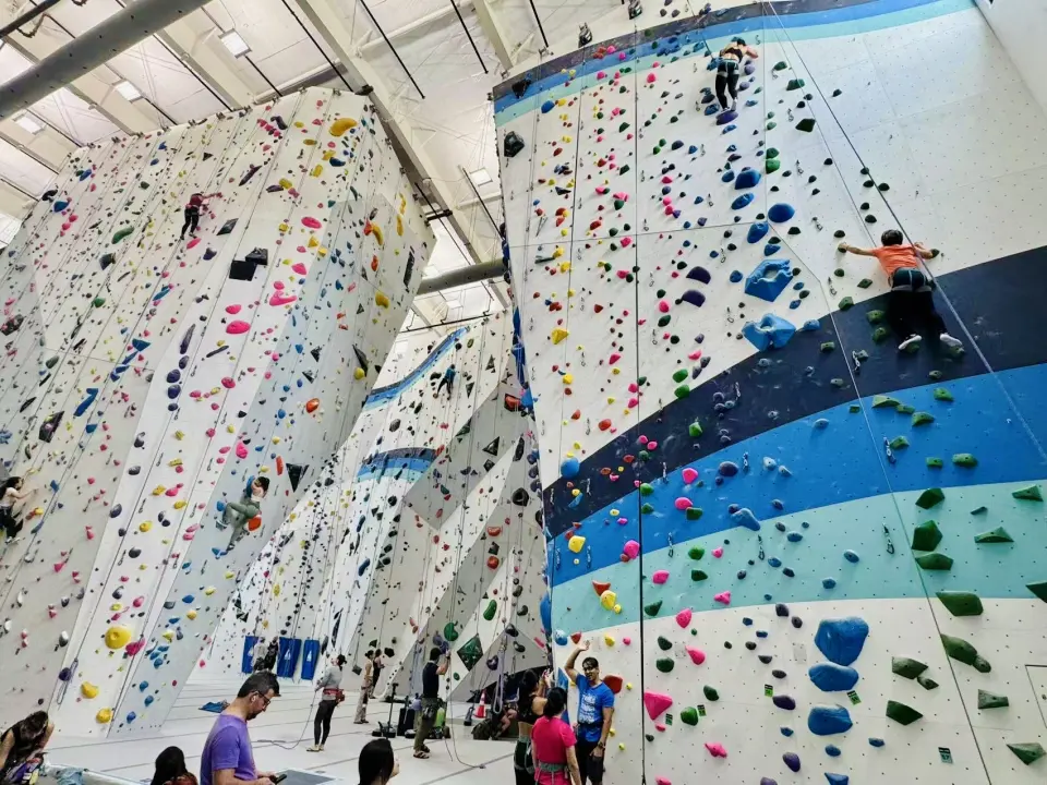 Climbers on the towering white and blue rope walls