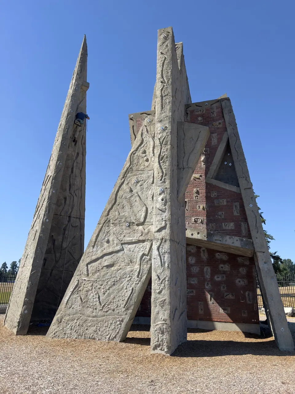 Concrete spires and brick climbing panels against a blue sky