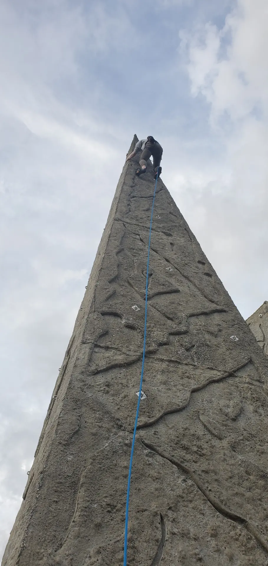 Climber topping out the tallest spire on a rope