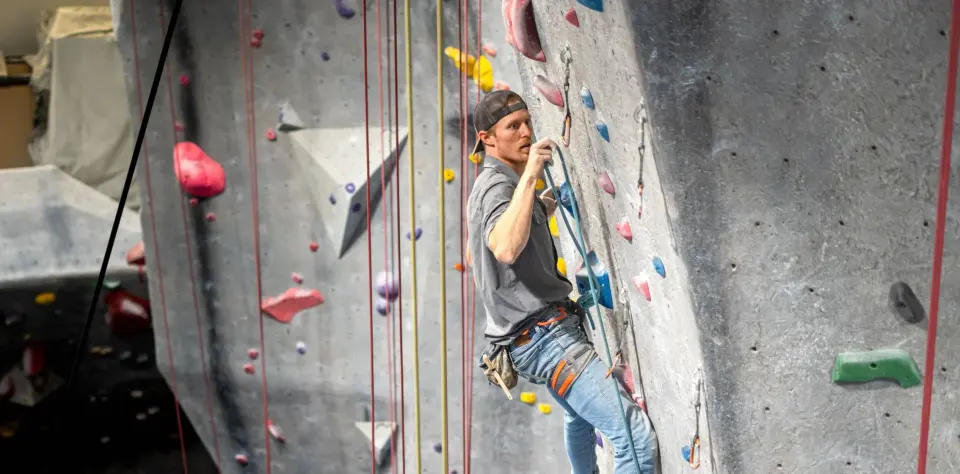 Climber on the tall grey rope walls at High Point Riverside