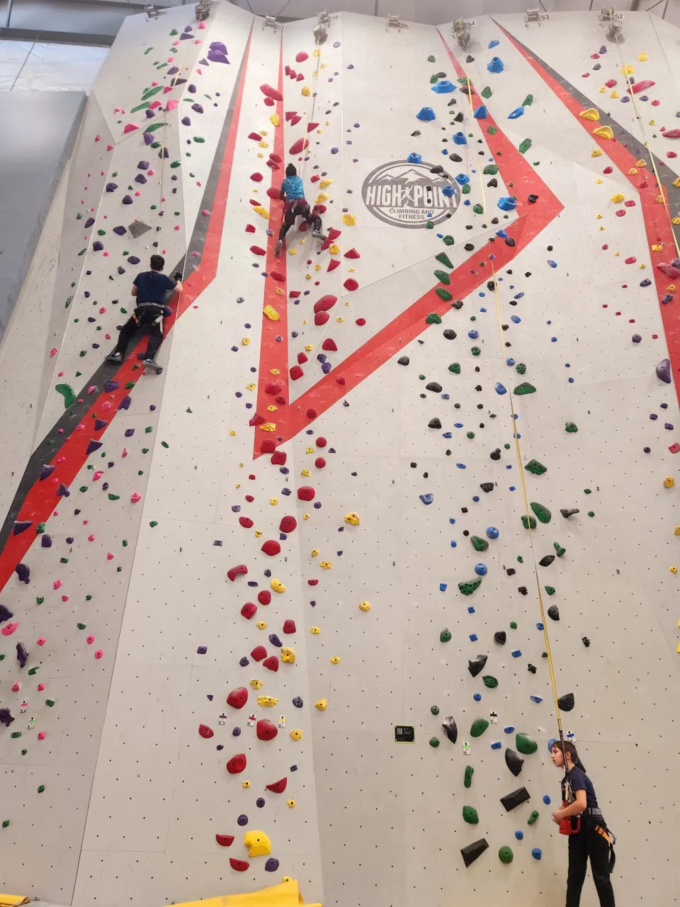 Tall rope wall with red stripes and top-rope lines