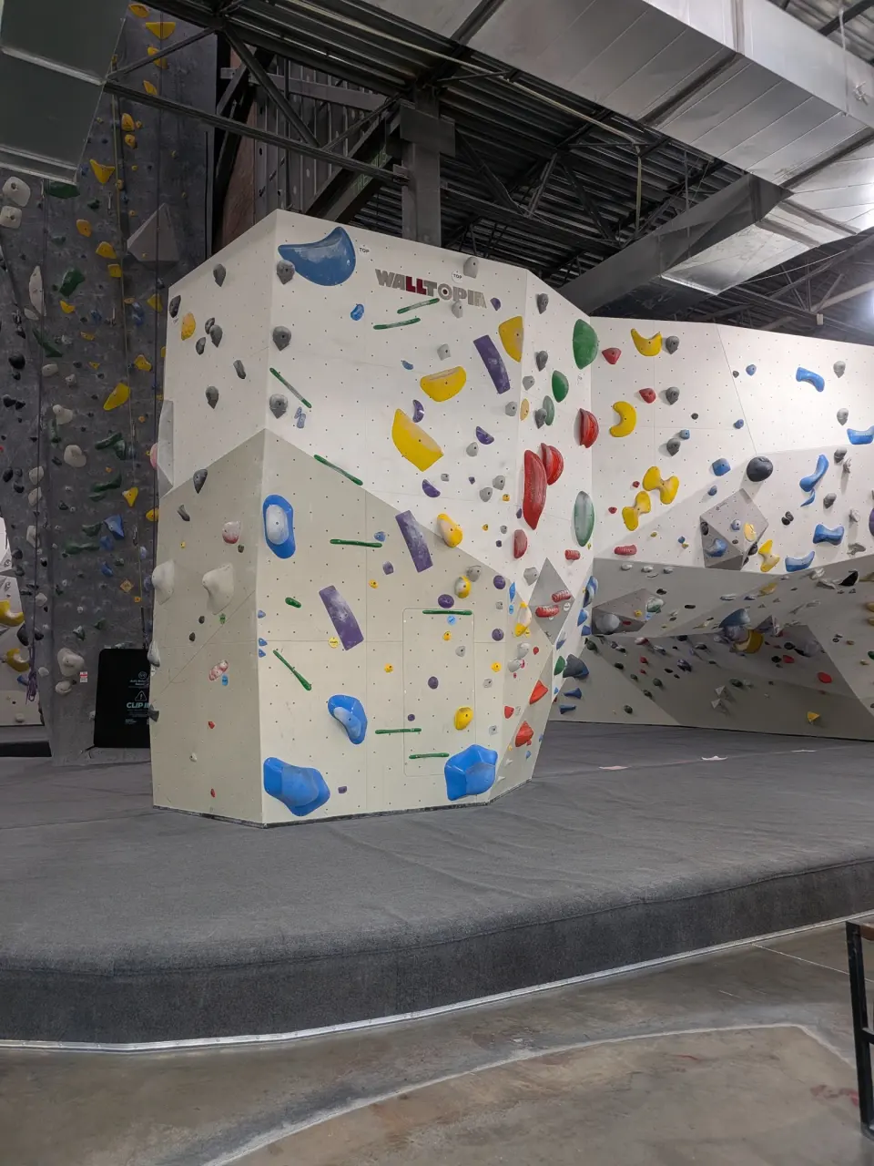 Free-standing boulder with colourful holds on a matted platform
