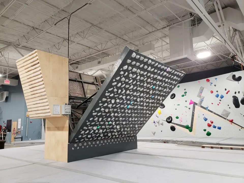 Adjustable training board beside the bouldering walls