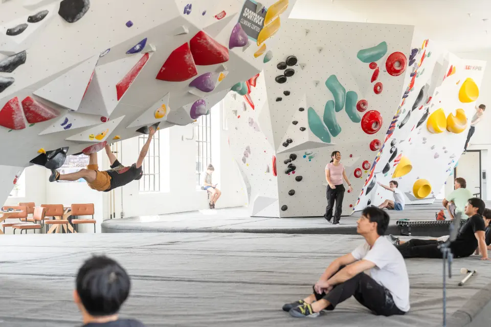 White boulders with red and teal holds in the bright bouldering hall