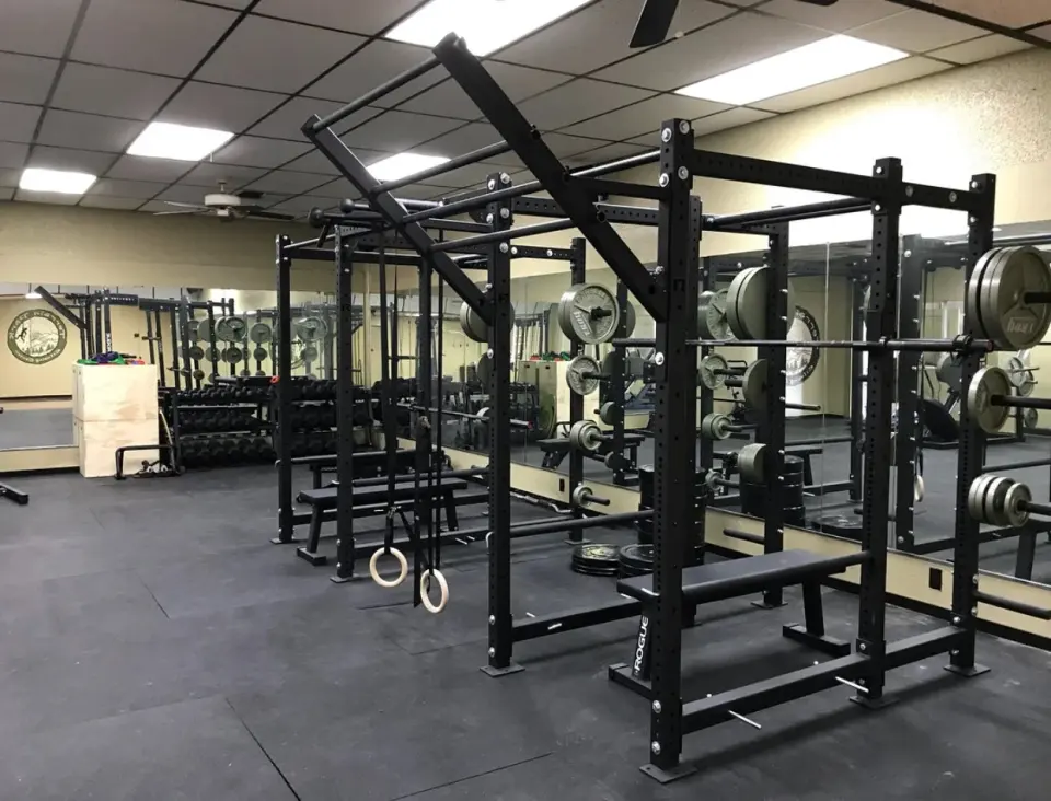 Weight room with squat racks and barbells