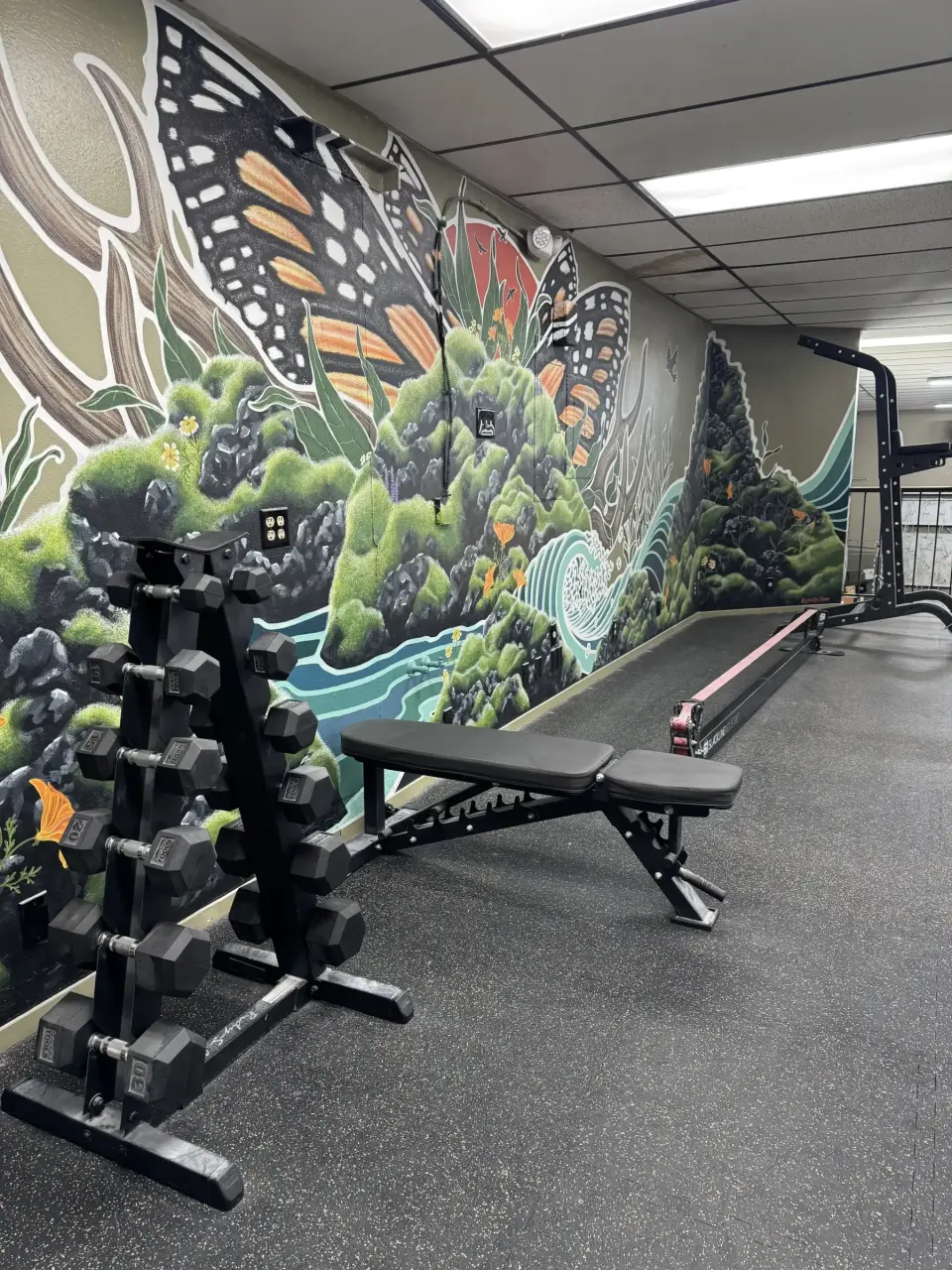 Upstairs fitness area beside a large mural