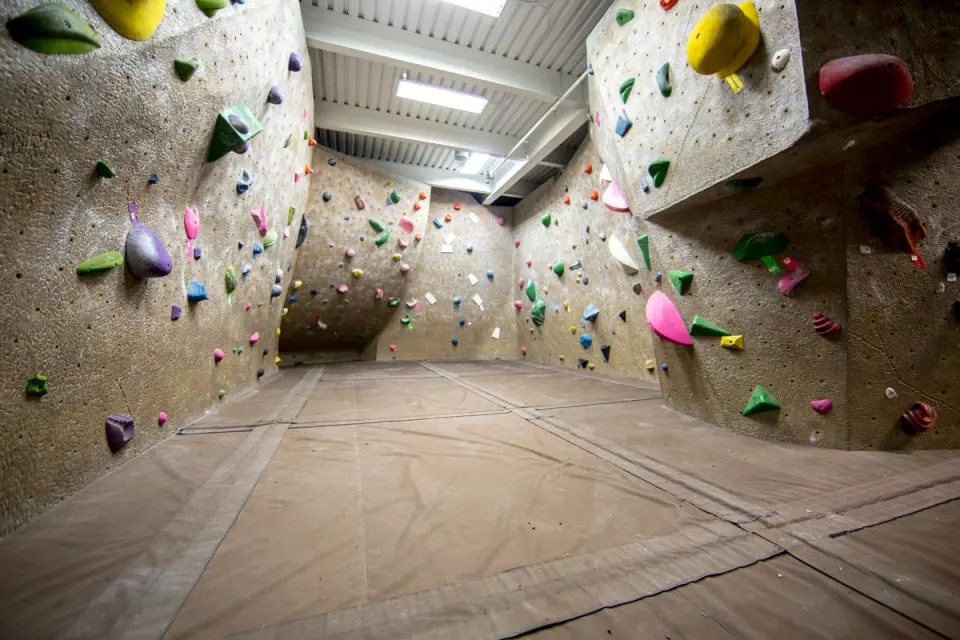 Bouldering area with angled walls above padded flooring
