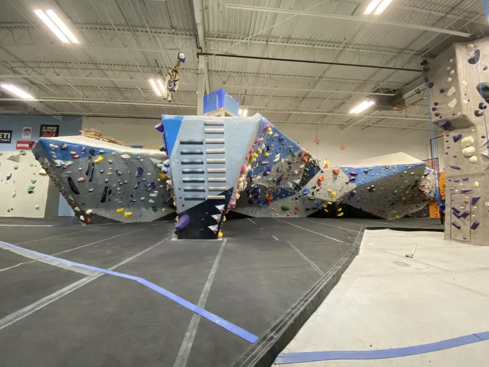 Free-standing blue and grey boulder in the middle of the bouldering area