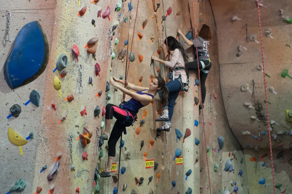 Climbers on a wall with a large blue volume