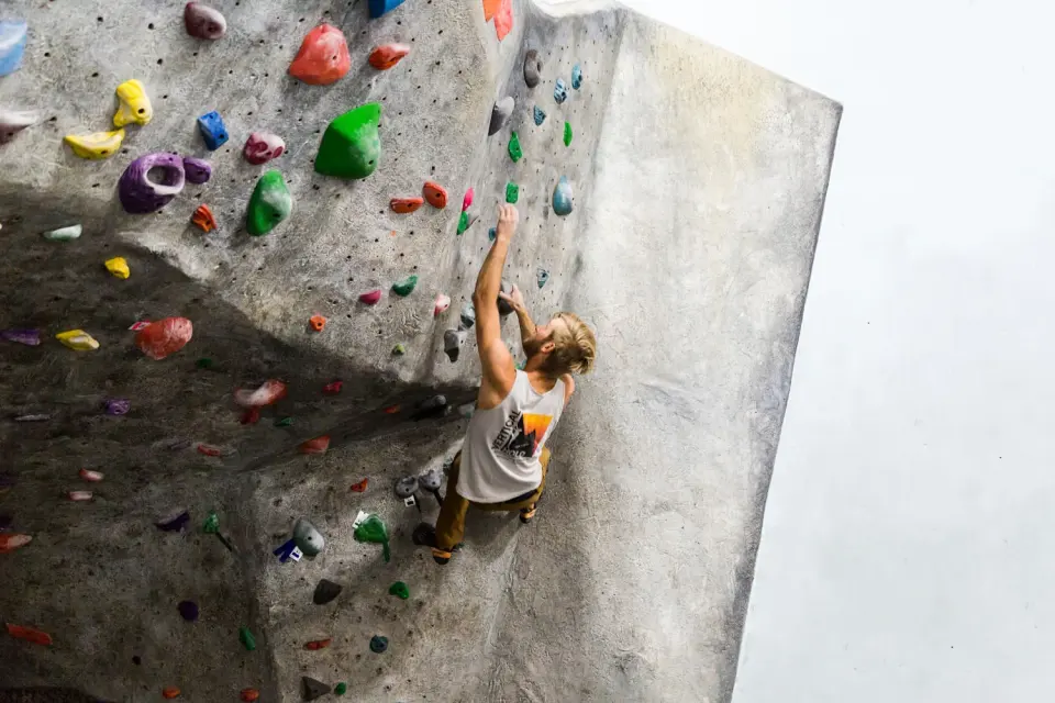 Climber on an overhanging grey boulder
