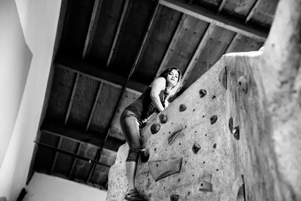 Black and white shot of a climber on a boulder under the roof