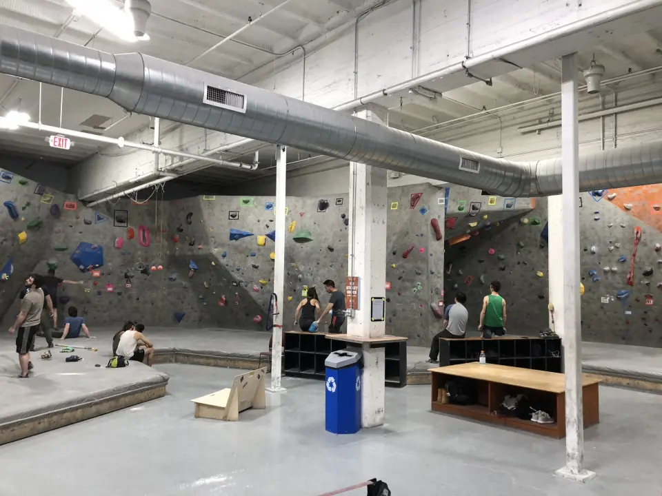 Wide view of the bouldering floor with cubbies and benches