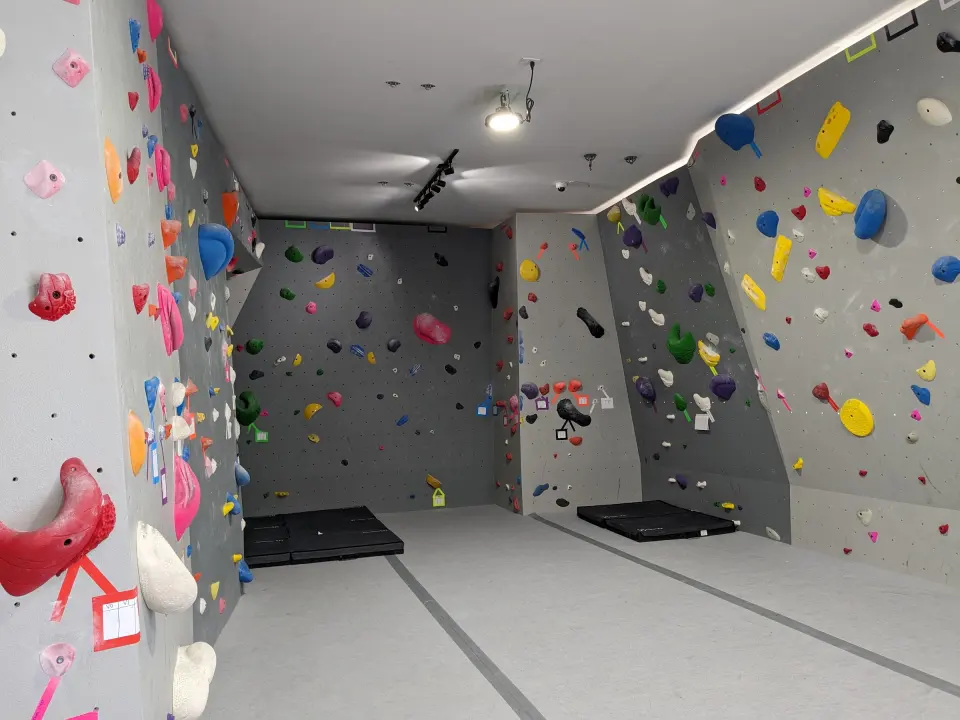 Bouldering walls on both sides of the main room with mats below