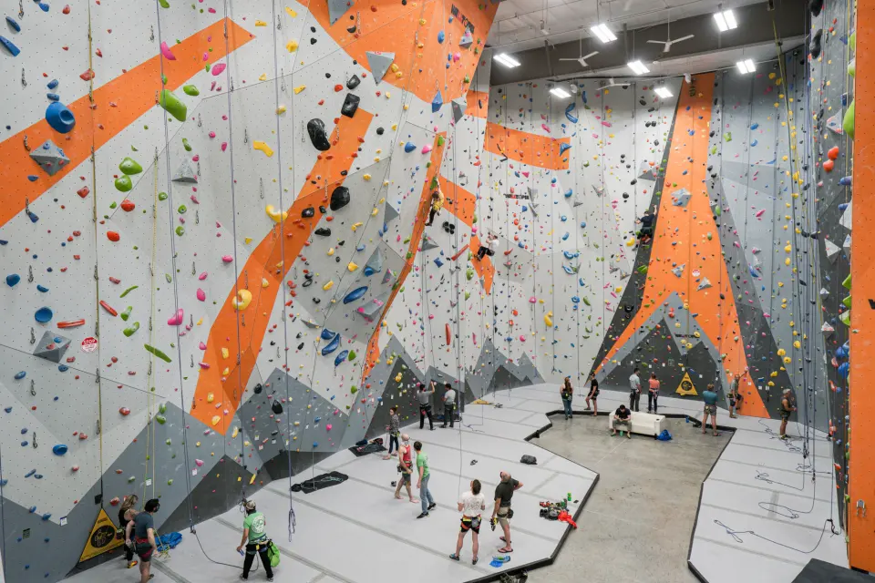 Climbers on the tall roped walls with orange stripes