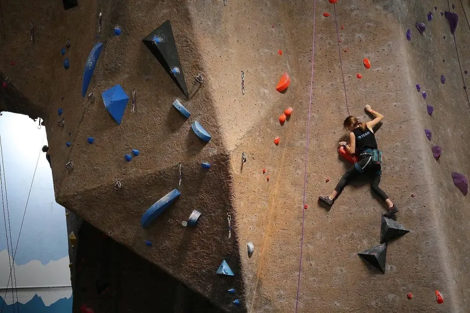 Climber on a tall textured rope wall