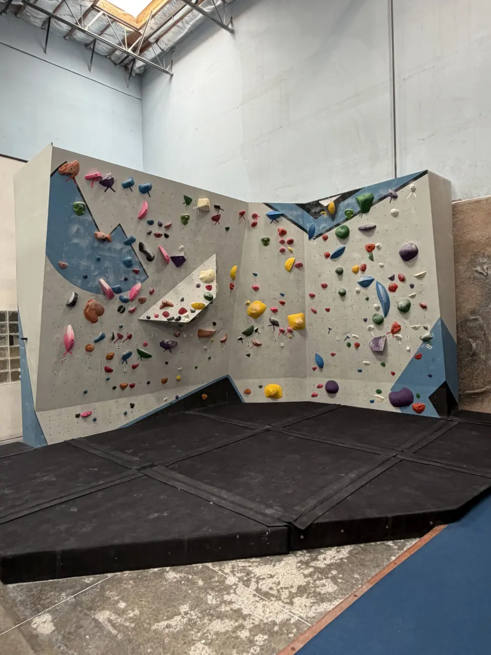 New grey and blue boulder wall above thick matting