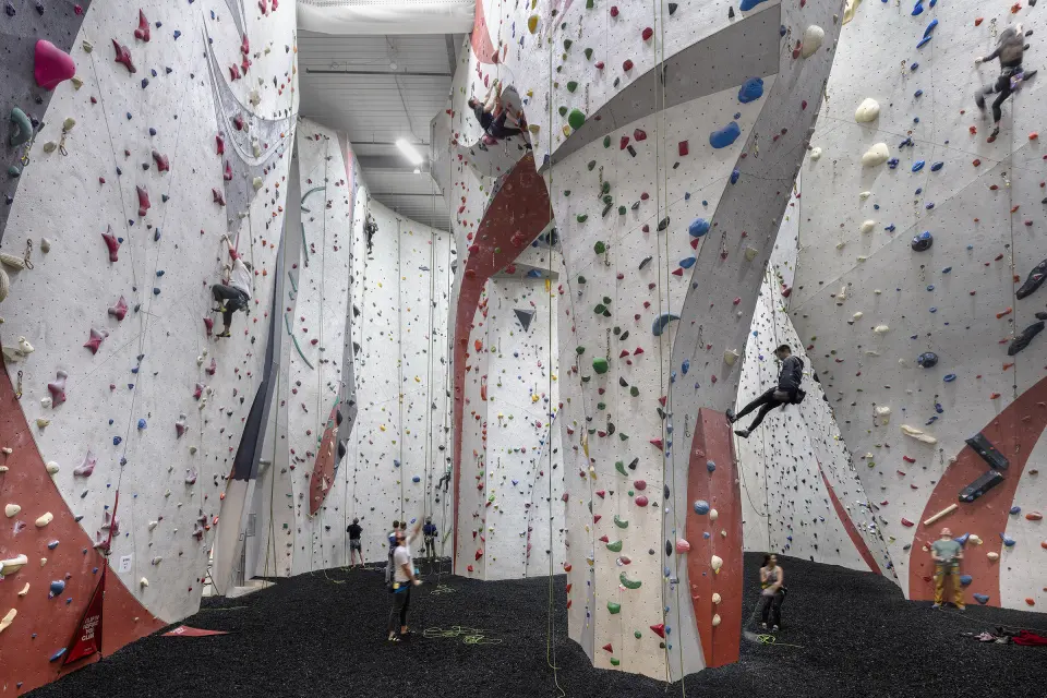 Climbers on the tall white and red rope walls of the atrium
