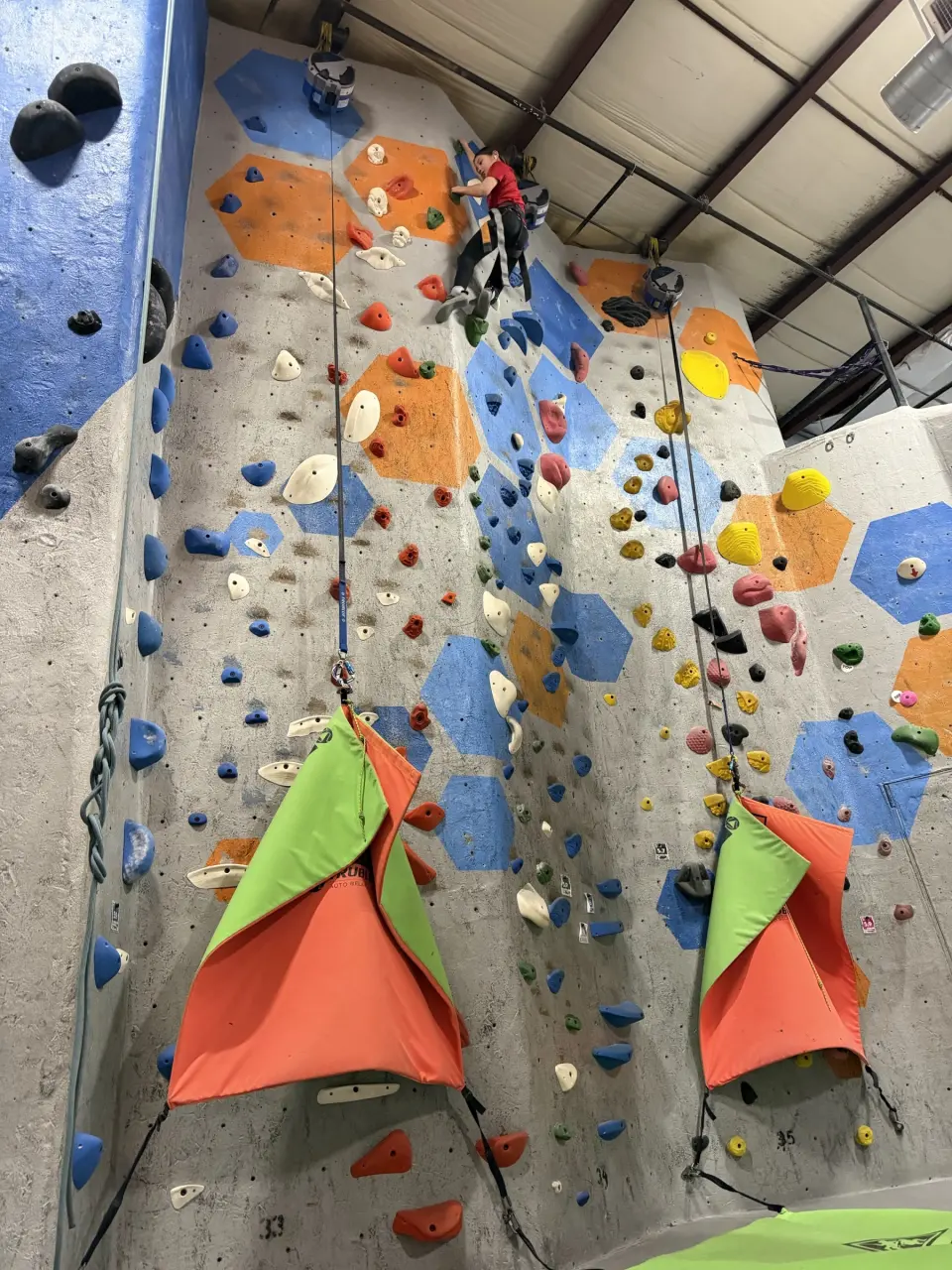 Two auto-belay lanes on a tall wall with hexagon panels