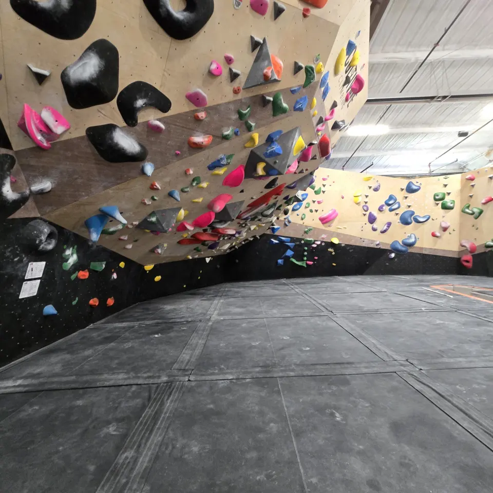 Overhanging wall and the long wall beyond, above padded matting