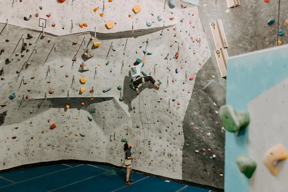 Main room with tall grey and blue lead walls and a climber high up