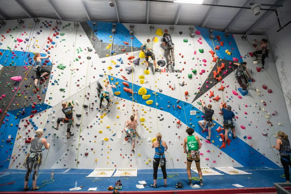 Climbers on the roped wall with blue and grey panels