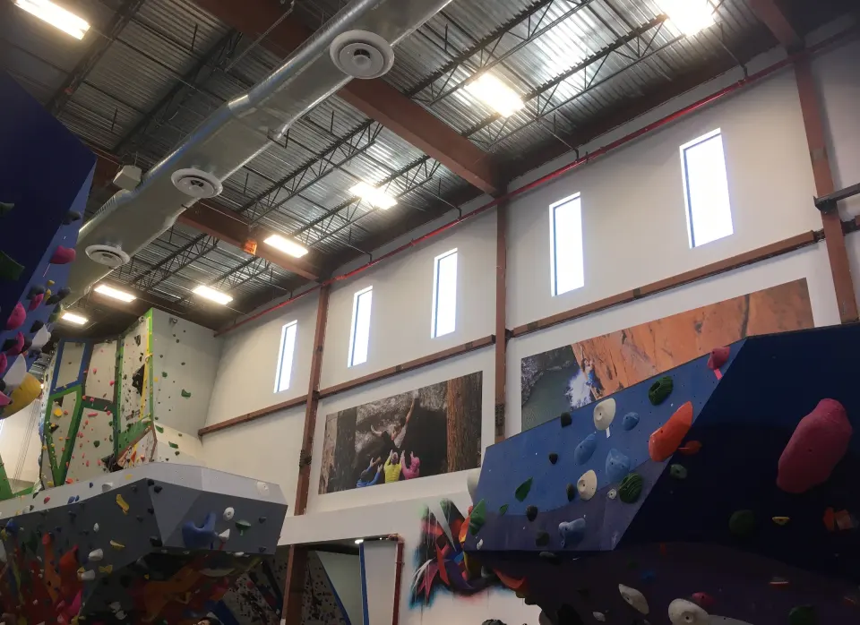 Bouldering area beneath high windows and murals